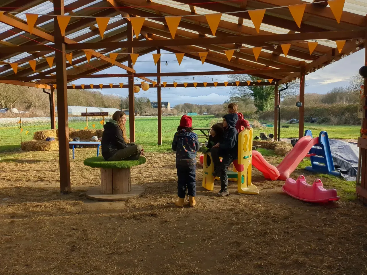 The farm shelter at Kirkstall Valley Farm with picnic benches, bunting and open fields beyond