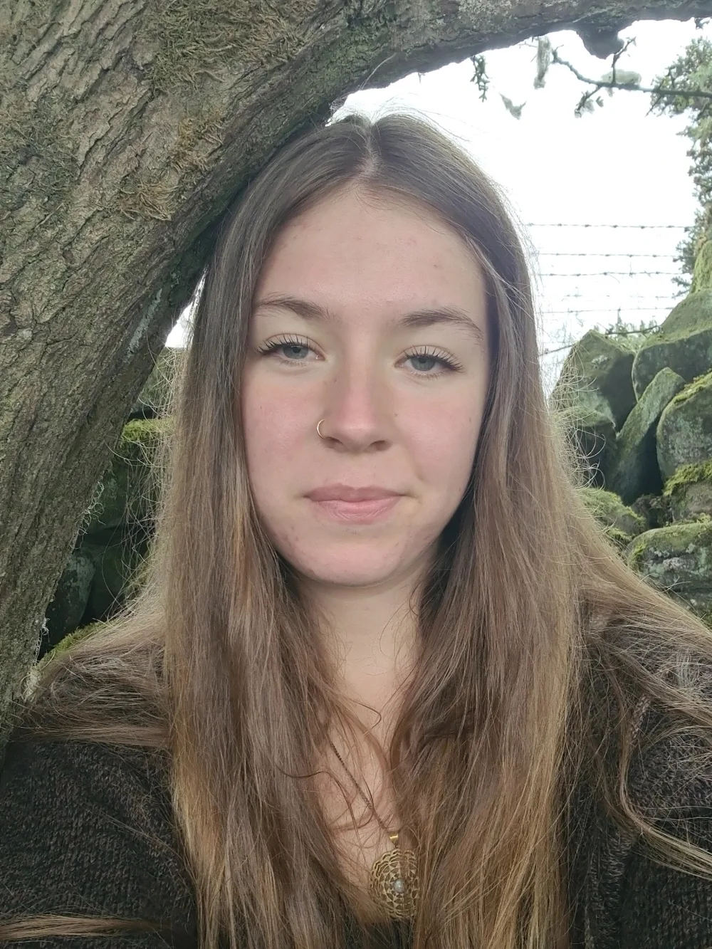 Katy, Co-Lead and Session Coordinator at Acorn to Oak, smiling outdoors by a tree